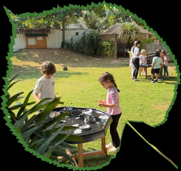 Children playing outdoors under a tree at Forest Oasis Nursery